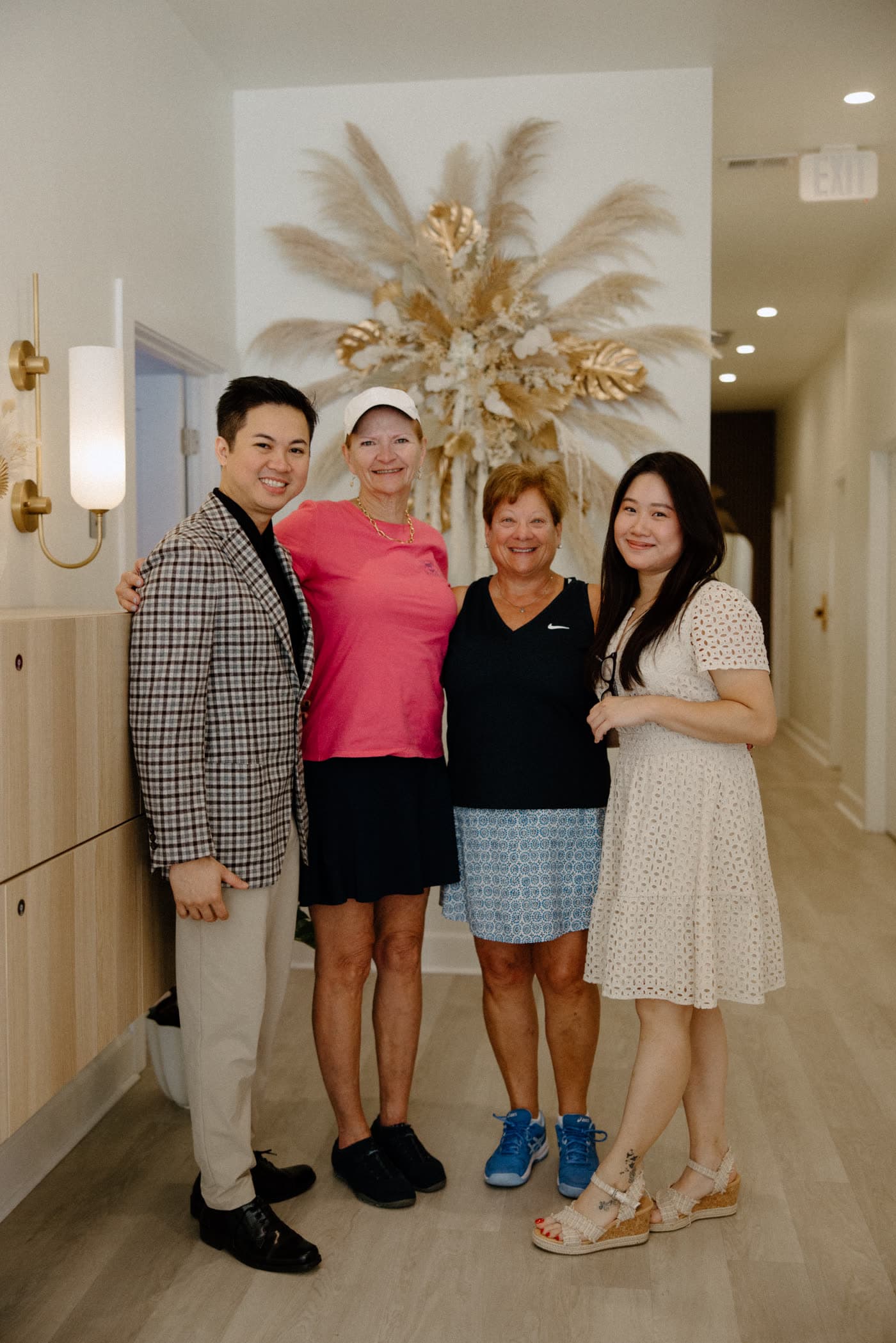 The Nail Talk & Spa owners and team, smiling together in the salon hallway